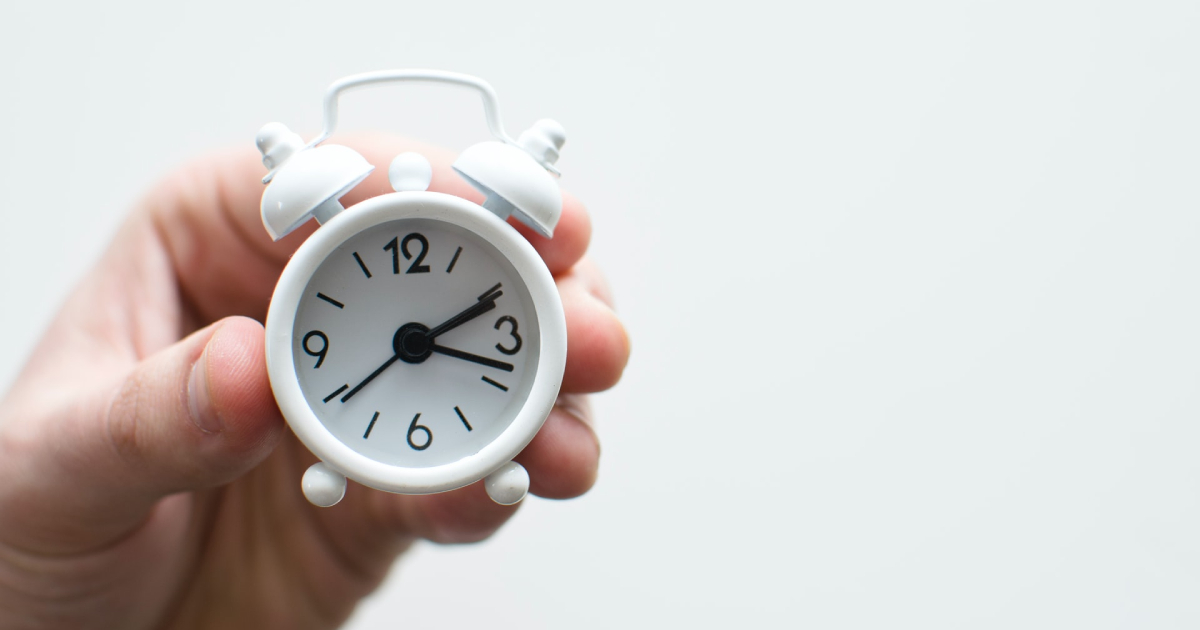 Hand holding alarm clock